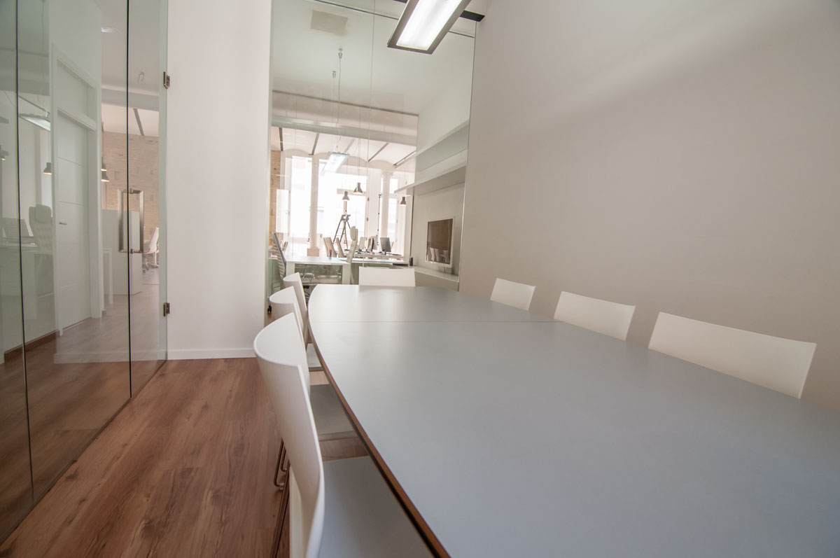 Sala de reuniones acristalada con mesa larga