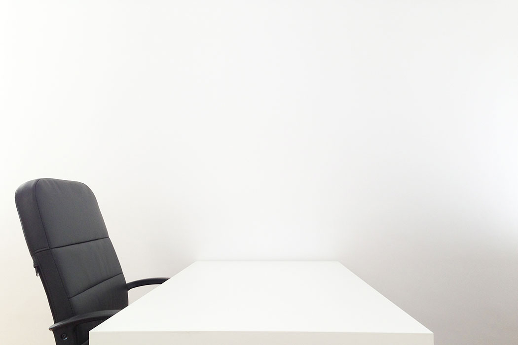 Mesa blanca y silla negra en un puesto del coworking